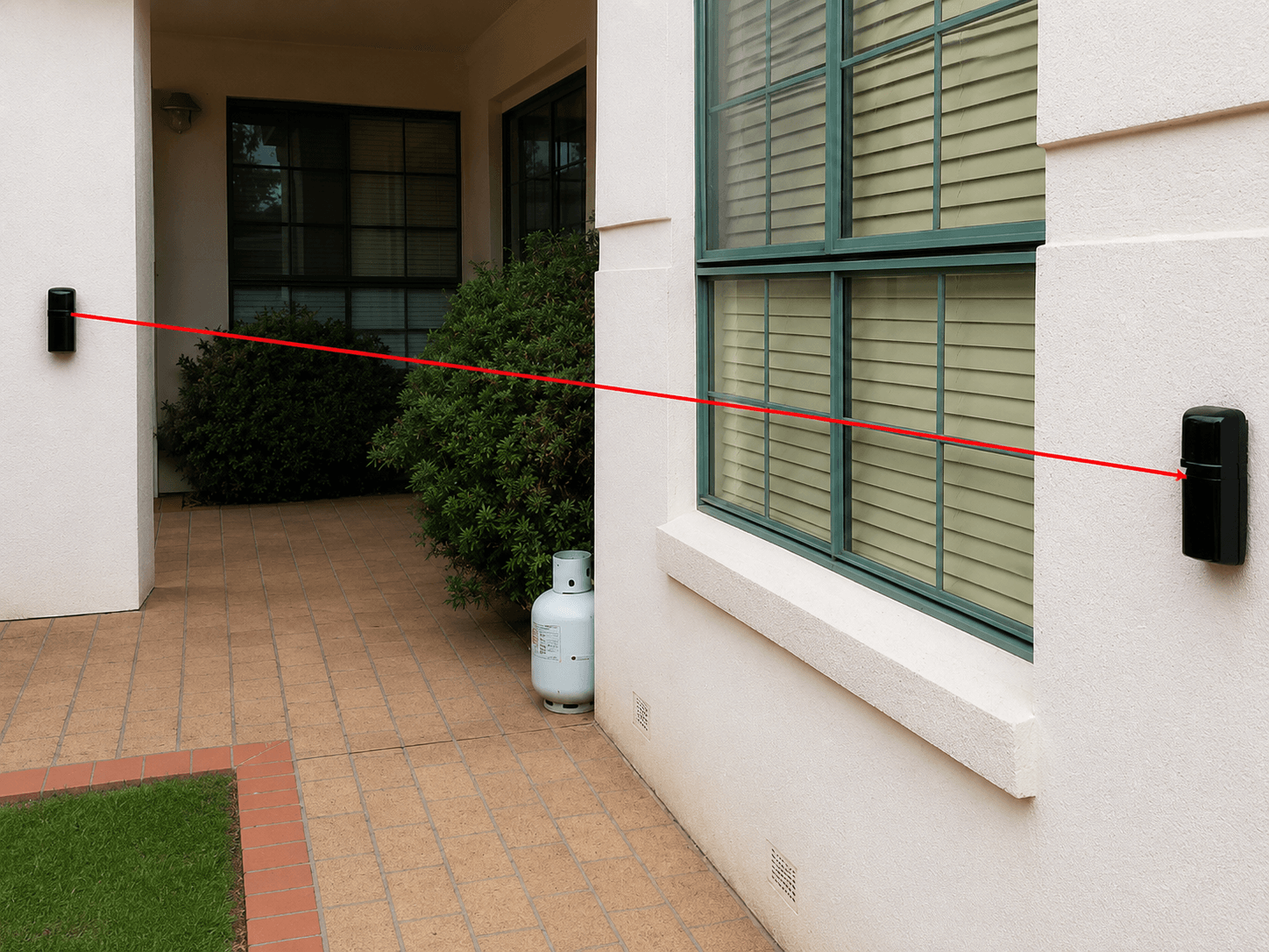 Wall-mounted photoelectric perimeter beam installed by Amaro Electronics